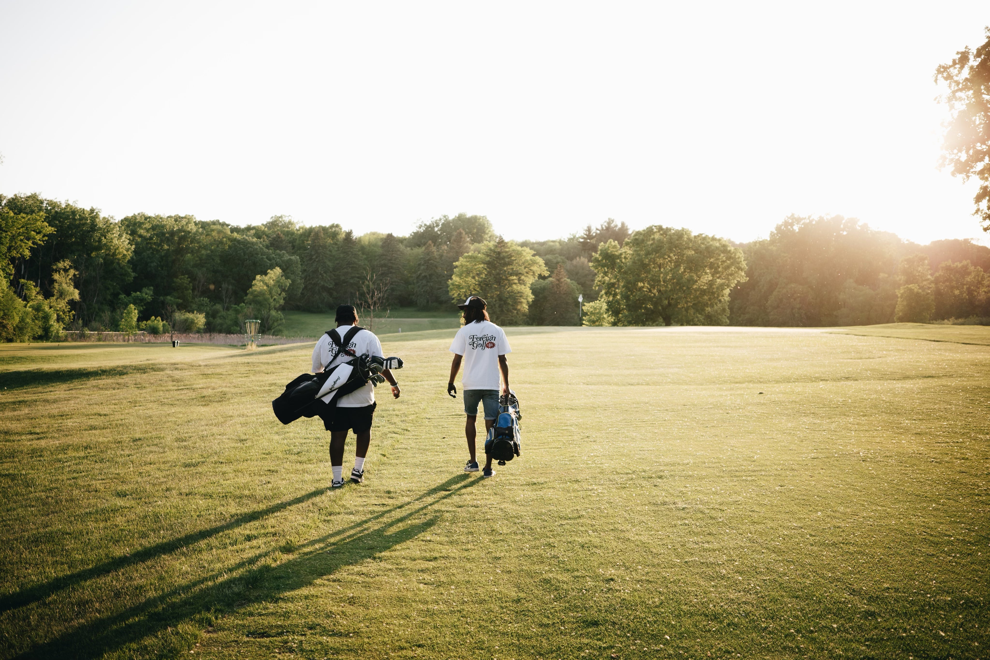 Two golfers walking on a beautiful golf course at golden hour